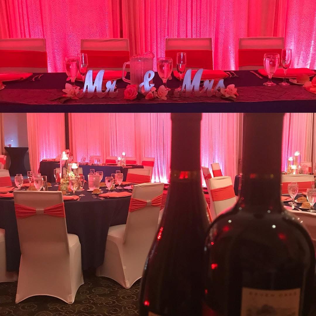 Wedding head table with Mr and Mrs signage under rose uplighting